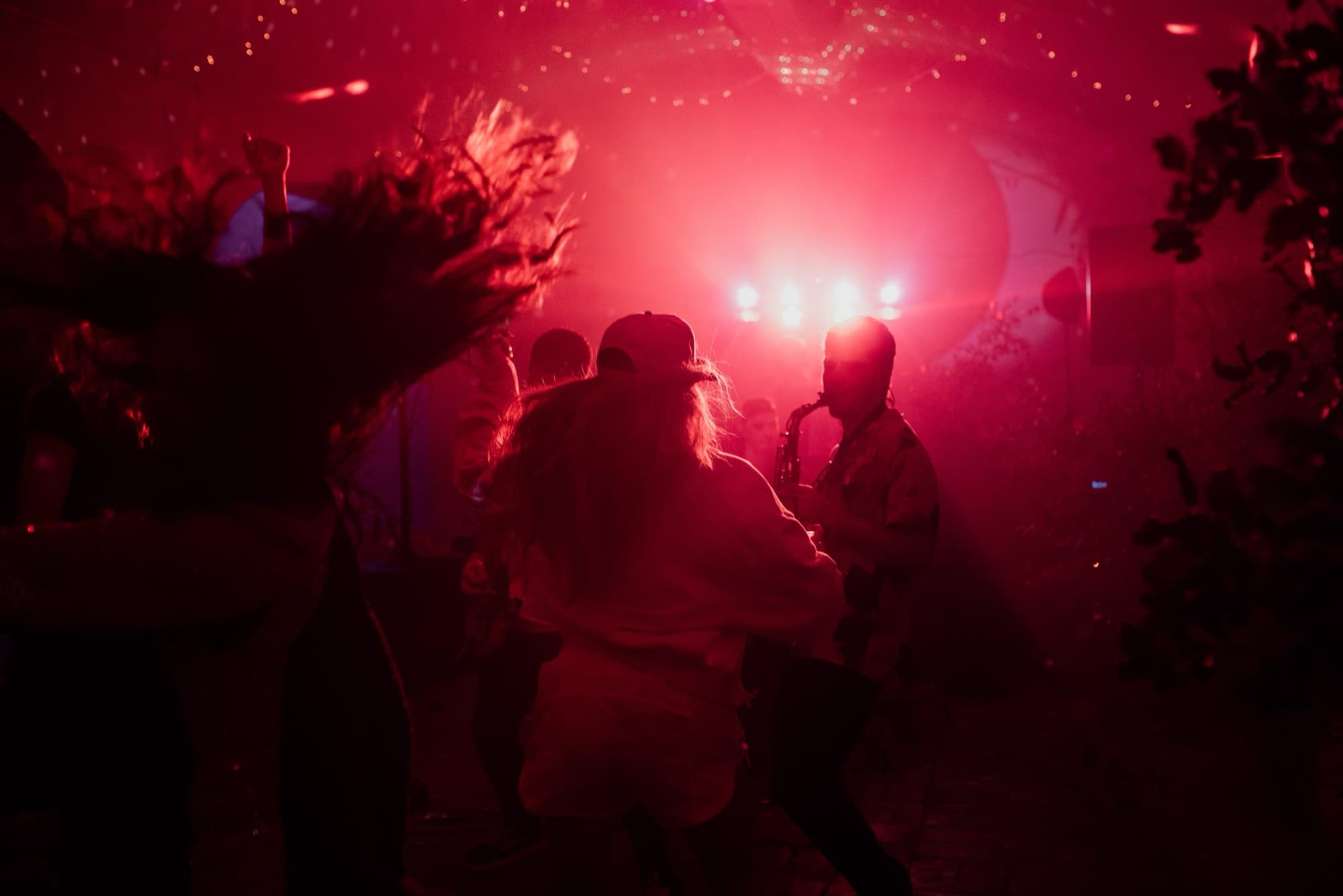 Large destination wedding dancefloor packed with guests during a DJ and live band peak set